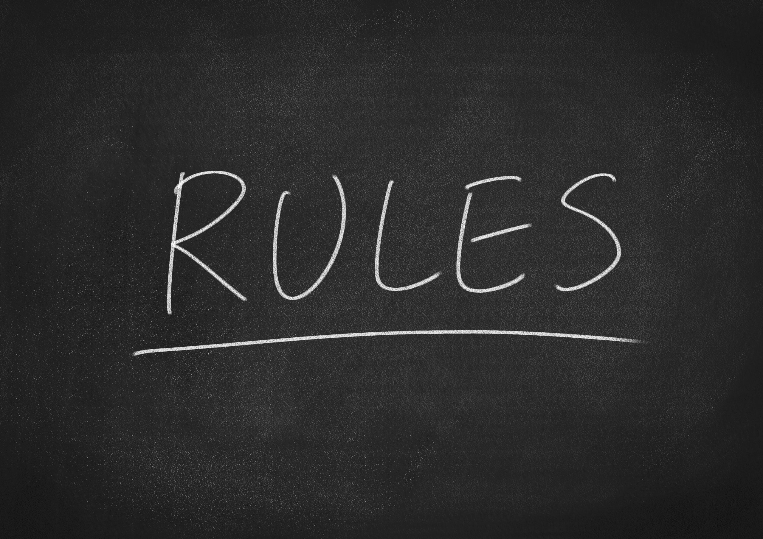 rules concept word on a chalkboard background