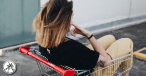 young woman sitting in a shopping cart with a tattoo