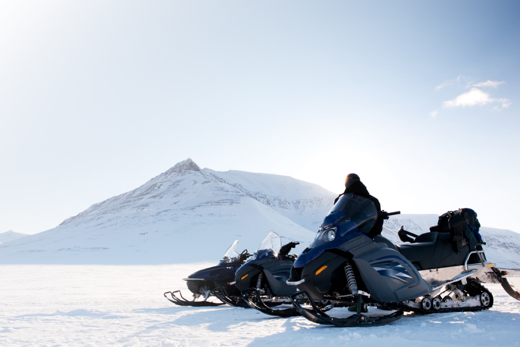 person in a snowy vista on a snowmobile