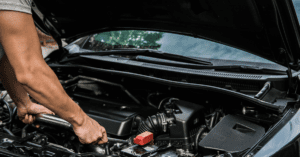 mechanic standing over an engine with an open hood