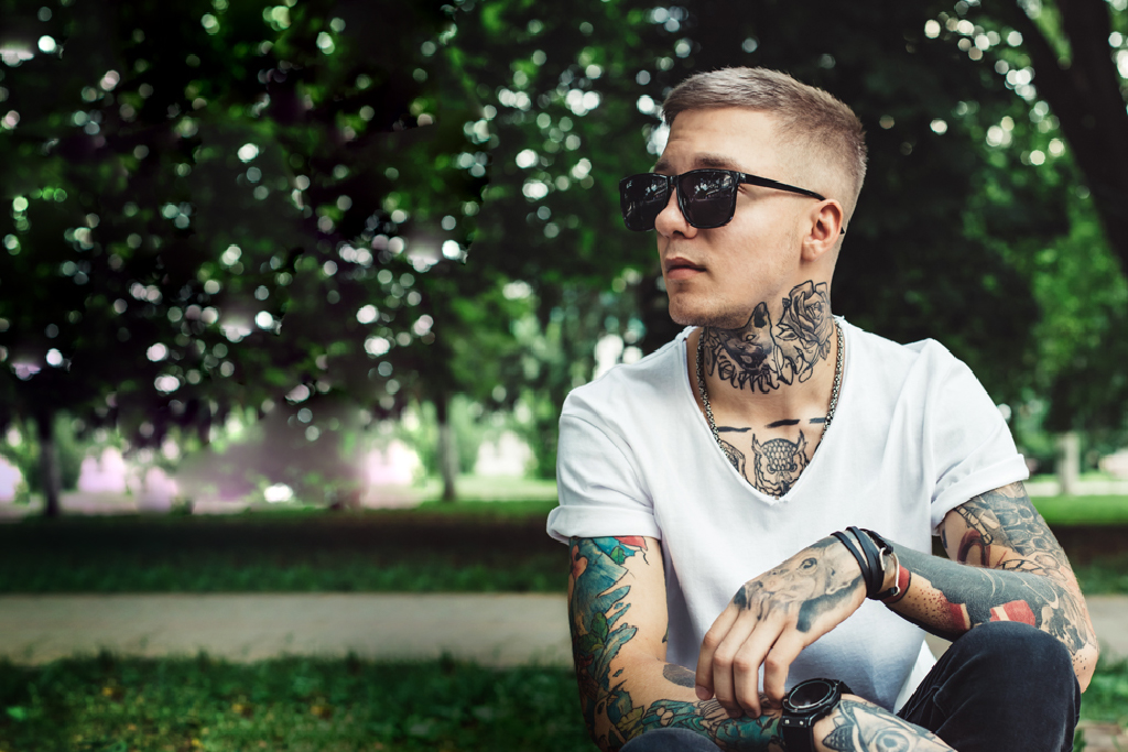 cool man with tattoos chilling in a park setting