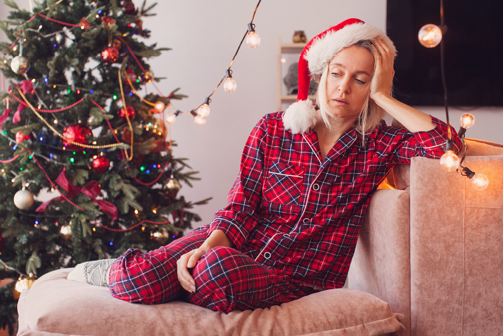 person tired on couch in holiday attire
