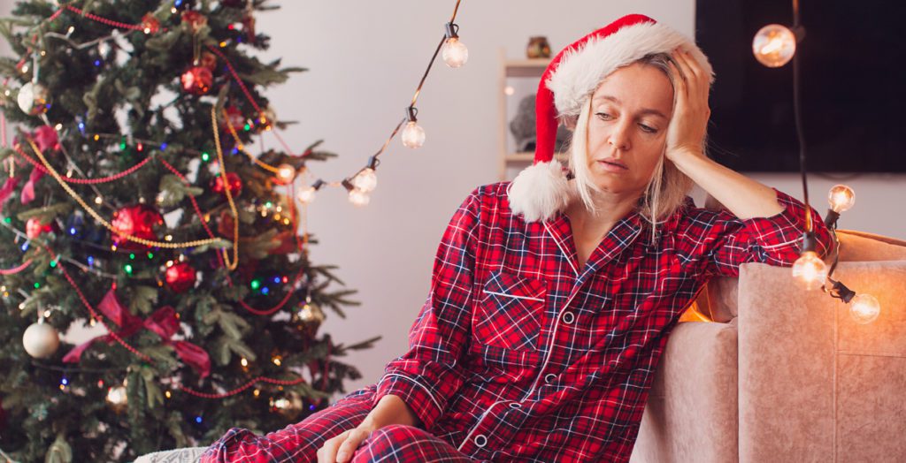 person tired on couch in holiday attire
