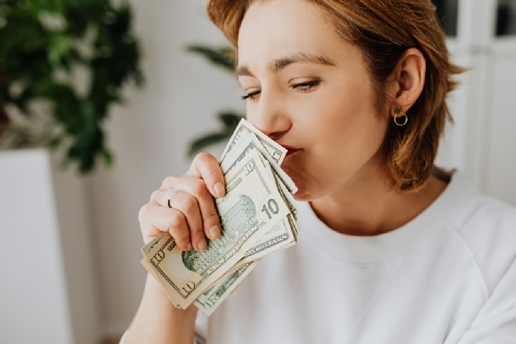 girl smelling a stack of money