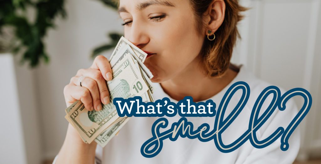 girl smelling a stack of money