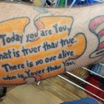 Dr. Seuss tattoo with a quote in a puzzle piece and cat in the hat hat