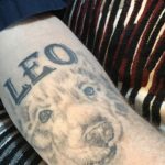 dog face tattoo with leo above it