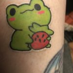 small tattoo of a frog holding a strawberry